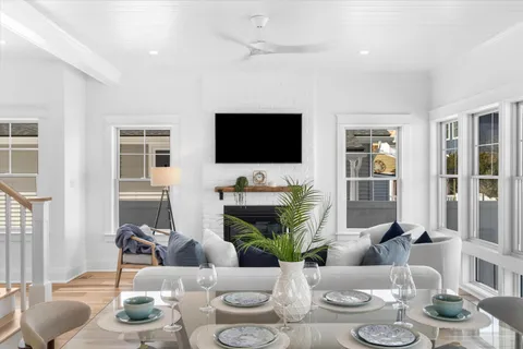 a living room with furniture a flat screen tv and a large window