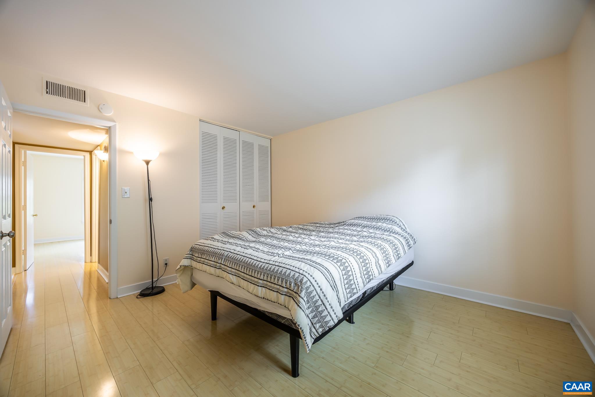 2527 Hydraulic Road, Unit 41 Charlottesville, VA 22901 - Photo 13 of 16 a bedroom with a bed and wooden floor