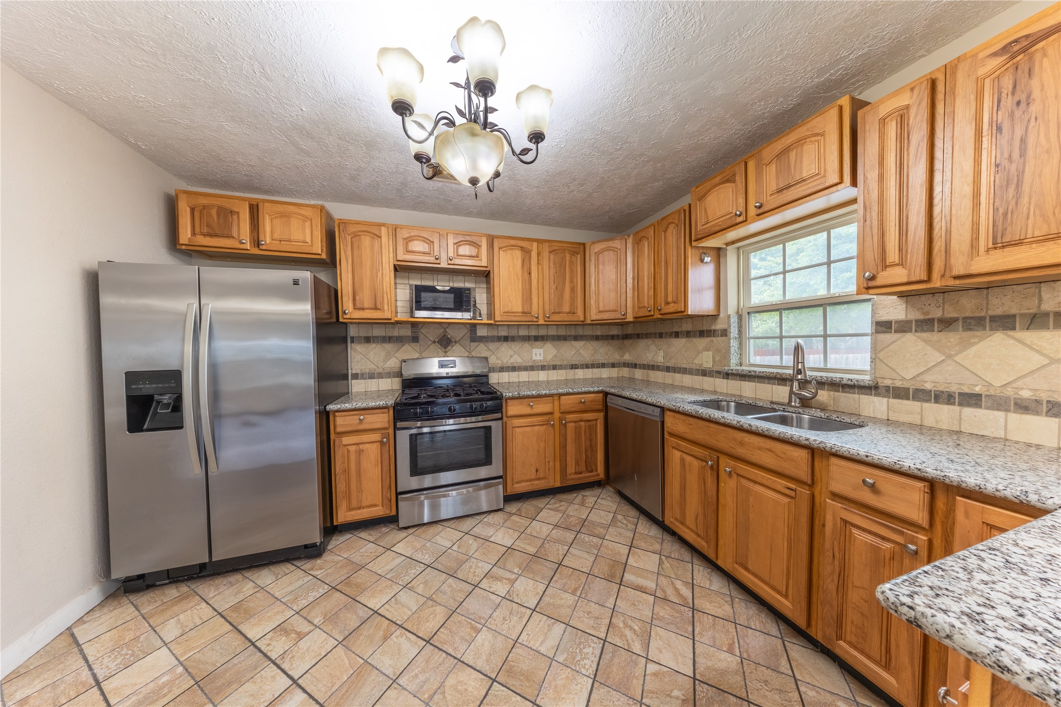 1229 West 21st Street Houston, TX 77008 - Photo 5 of 25 a kitchen with stainless steel appliances granite countertop a refrigerator a sink dishwasher a stove with wooden cabinets and floor