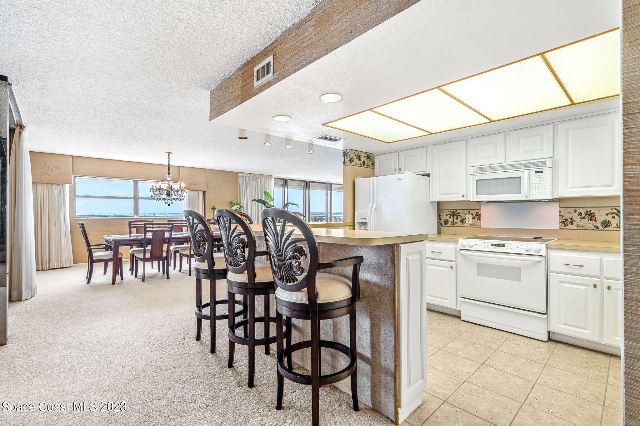 877 N Highway, Unit 1304 Indialantic, FL 32903 - Photo 4 of 24 a kitchen with a table chairs sink and cabinets