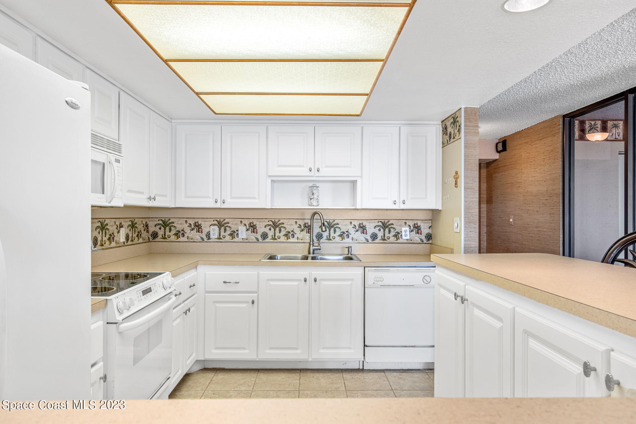 877 N Highway, Unit 1304 Indialantic, FL 32903 - Photo 5 of 24 a kitchen with granite countertop white cabinets and white appliances