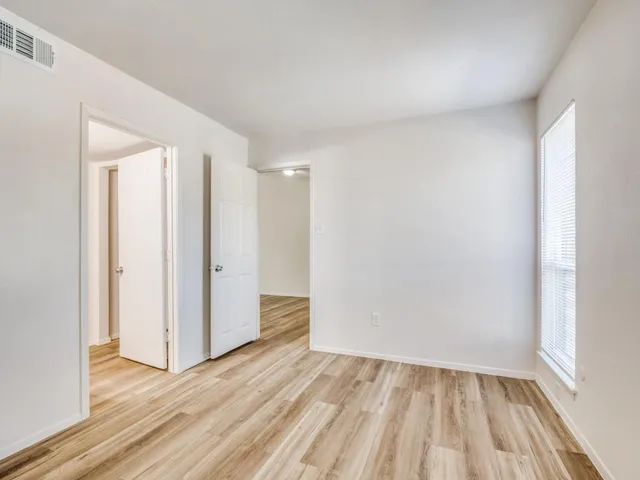 a view of an empty room and wooden floor