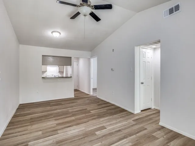 a view of empty room with wooden floor