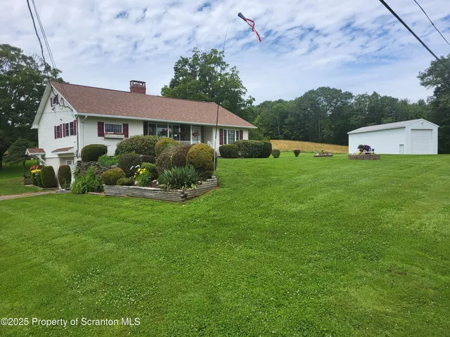 a dining room with a stove a sink dishwasher a dining table and chairs with wooden floor