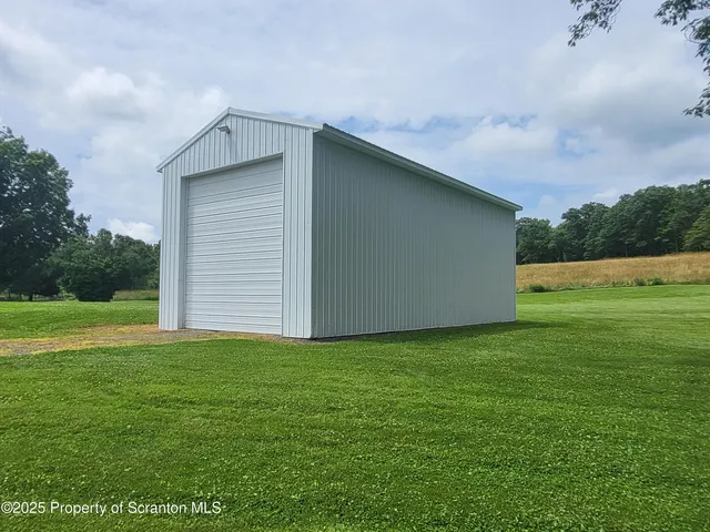 a front view of a house with garden and trees
