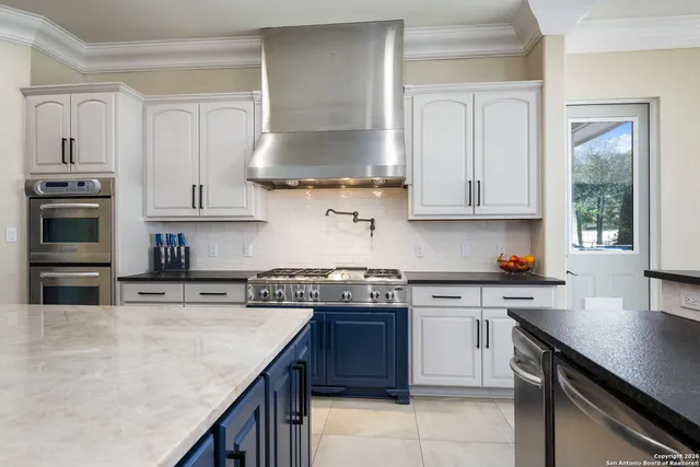 a kitchen with stainless steel appliances granite countertop a stove a sink and a microwave