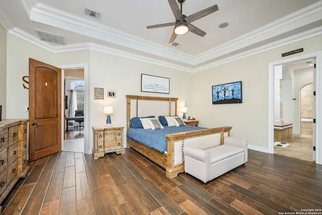 a spacious bedroom with a bed and wooden floor