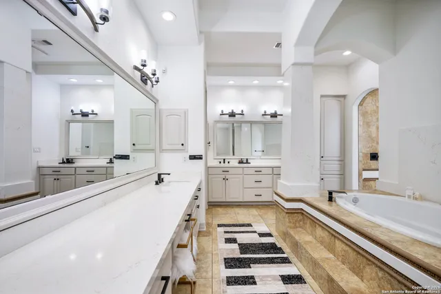 a large white kitchen with a large counter top a sink and appliances