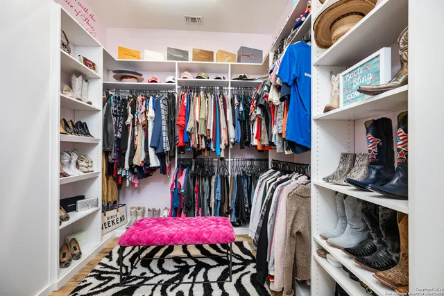 a view of walk in closet with clothes and shoes