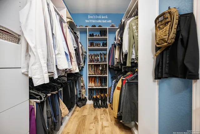 a view of walk in closet with clothes and shoes
