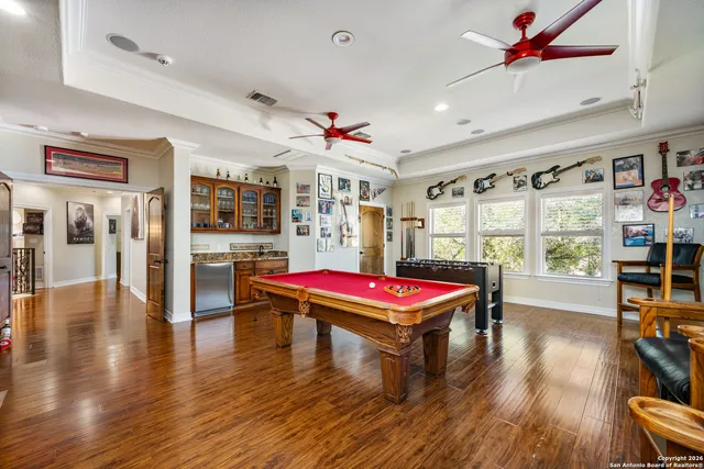 a living room with furniture pool table wooden floor and a window