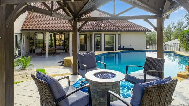 a view of a patio with table and chairs barbeque potted plants and large tree