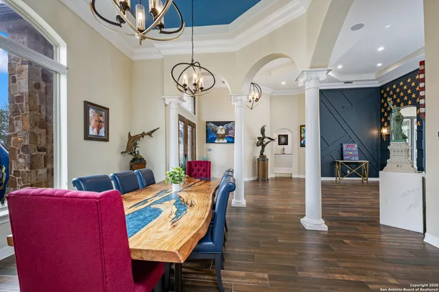 a living room with furniture a chandelier and a wooden floor