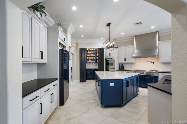 a large kitchen with stainless steel appliances kitchen island granite countertop a stove and a sink