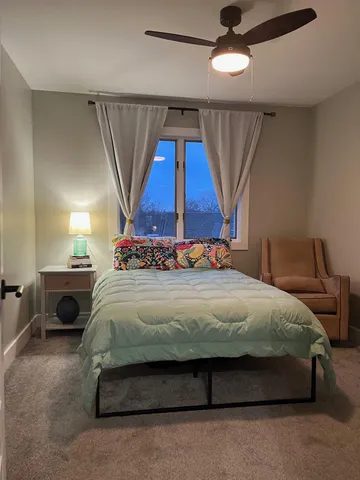 a bedroom with a bed window and table