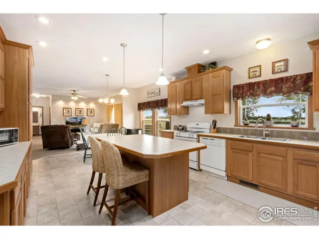 a open kitchen with stainless steel appliances kitchen island granite countertop a sink table and chairs