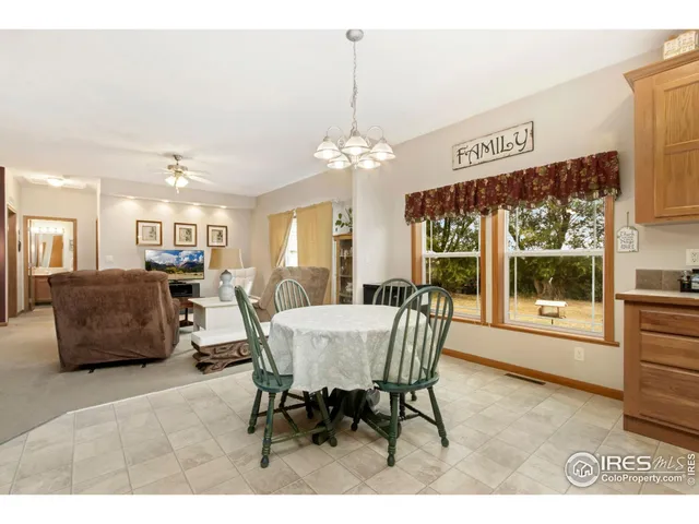 a dining room with furniture a chandelier and window
