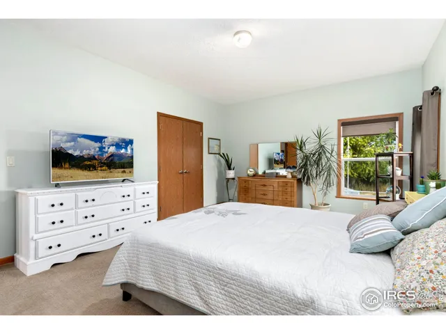 a bedroom with a bed and flat screen tv