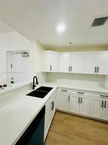 a kitchen that has a sink and cabinets