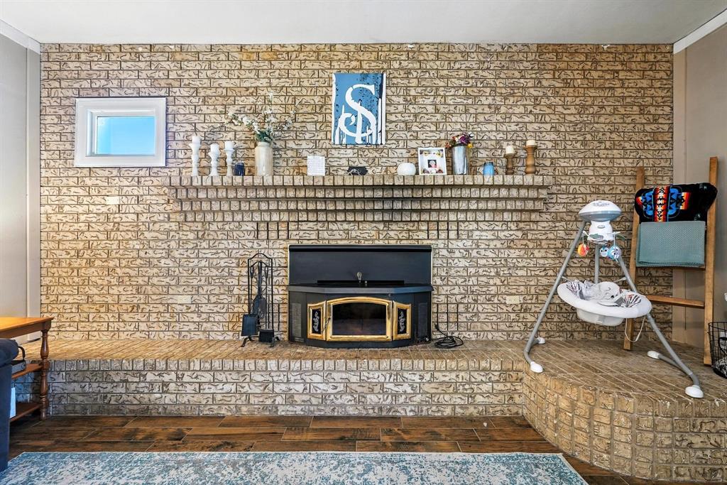 1017 Northwest 2nd Street Hamlin, TX 79520 - Photo 16 of 29 a room with fireplace and wooden floor