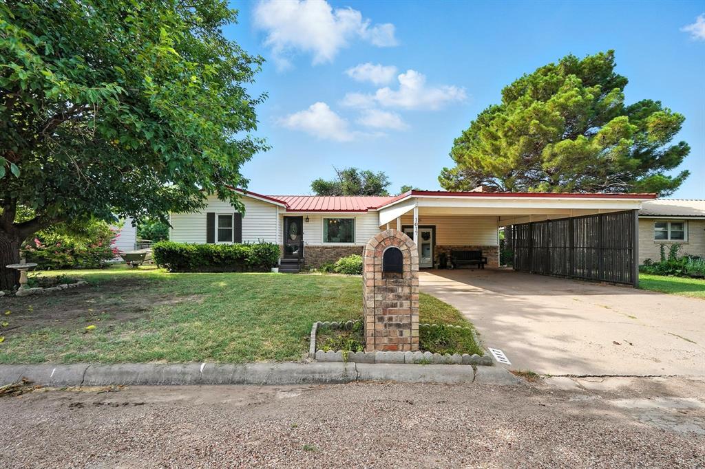 1017 Northwest 2nd Street Hamlin, TX 79520 - Photo 2 of 29 a front view of a house with a yard and a garage