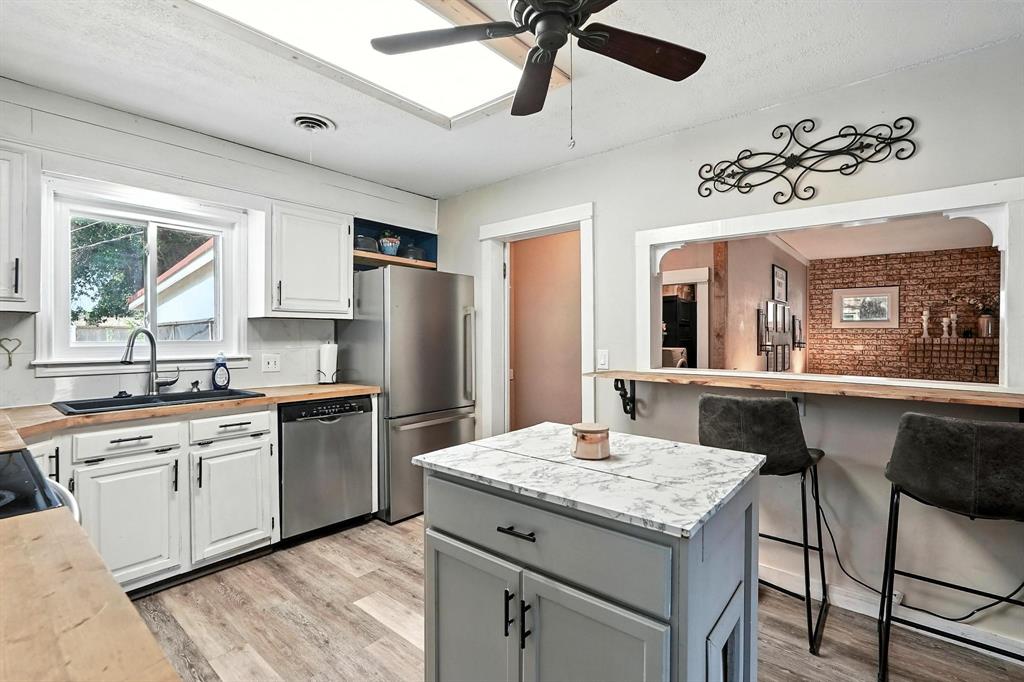 1017 Northwest 2nd Street Hamlin, TX 79520 - Photo 5 of 29 a kitchen with granite countertop kitchen island stainless steel appliances a sink stove and refrigerator