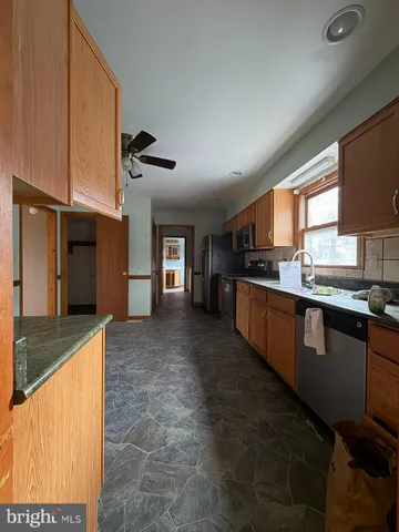 a kitchen with granite countertop a sink cabinets and stainless steel appliances