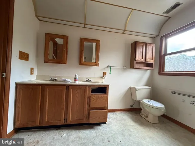 a bathroom with a granite countertop toilet sink and mirror