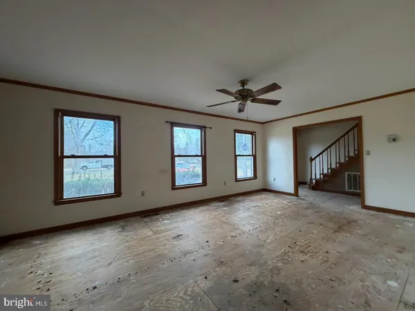 an empty room with windows and ceiling fan