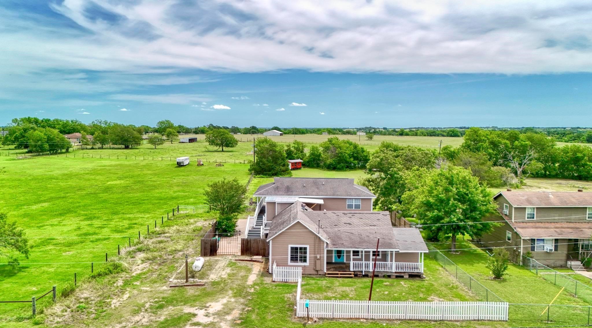 an aerial view of house with yard and mountain view in back