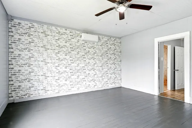 en empty room with wooden floor and ceiling fan