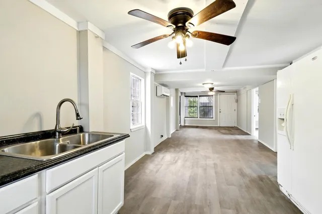 a kitchen with stainless steel appliances kitchen island a sink and wooden floor