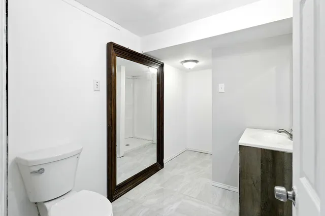 a bathroom with a toilet shower and sink