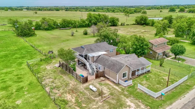 an aerial view of a house with big yard