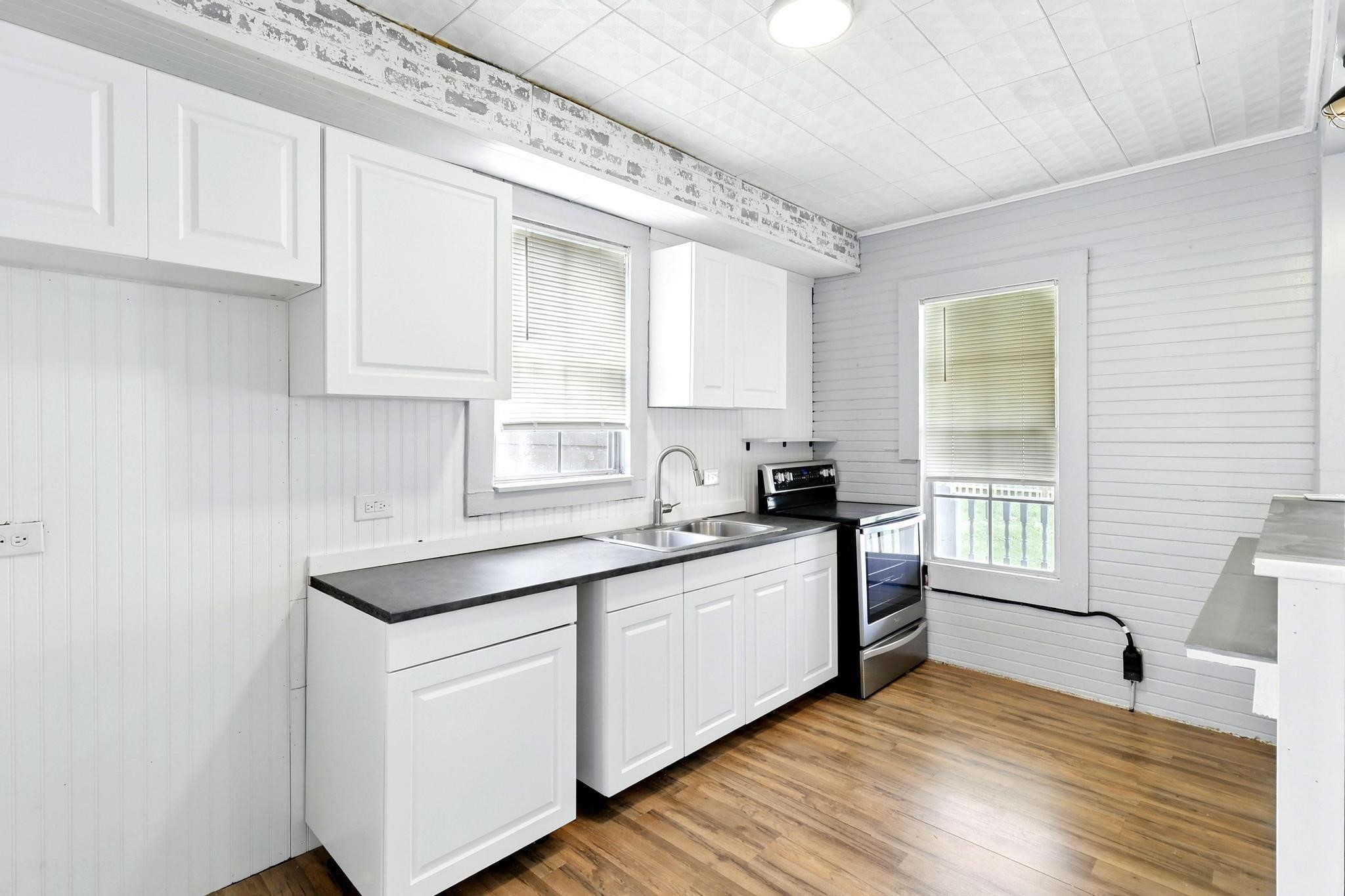 307 Shepard Lane Brenham, TX 77833 - Photo 5 of 47 a kitchen with stainless steel appliances granite countertop a sink and cabinets with wooden floor