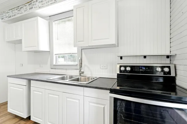 a kitchen with granite countertop white cabinets and appliances