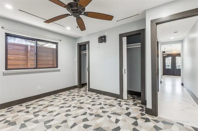a view of a big room with wooden floor and a chandelier fan