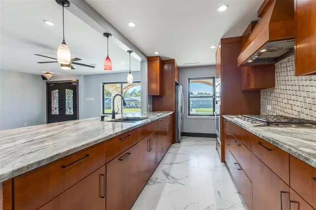 a large kitchen with stainless steel appliances granite countertop a large counter top and a stove