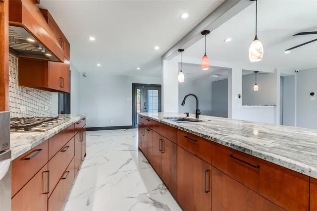 a large kitchen with stainless steel appliances granite countertop a sink and a stove