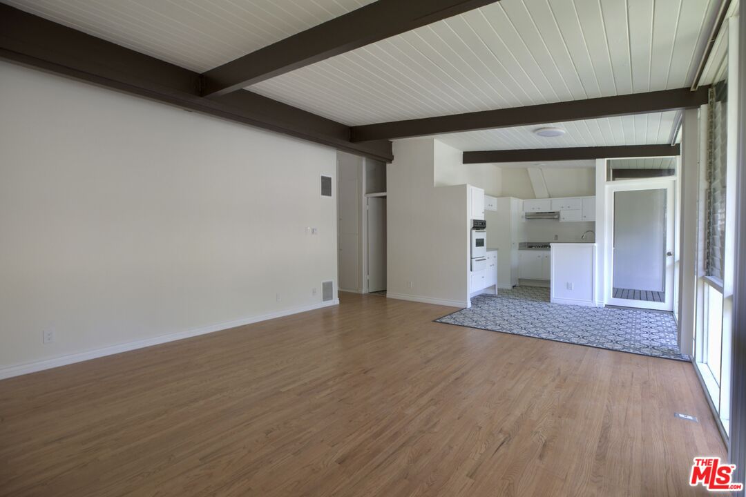 an empty room with wooden floor and bathroom