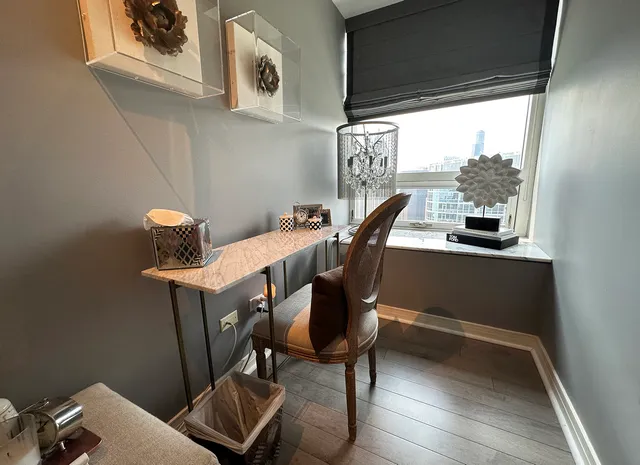 a view of a workspace with furniture and a window