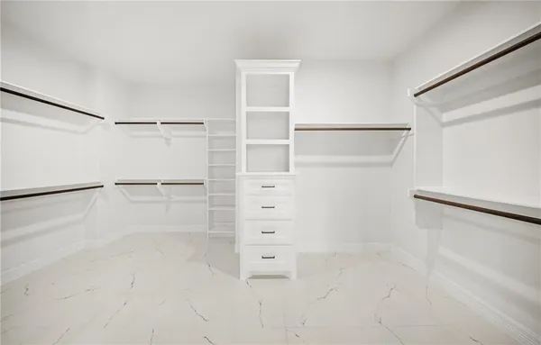 a view of walk in closet with empty racks