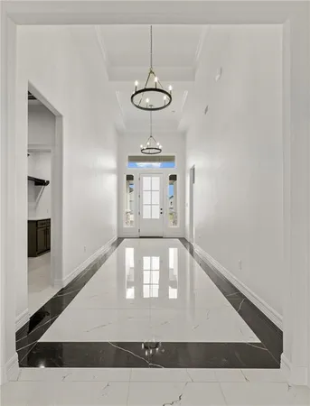 a view of a hallway with a chandelier and entryway