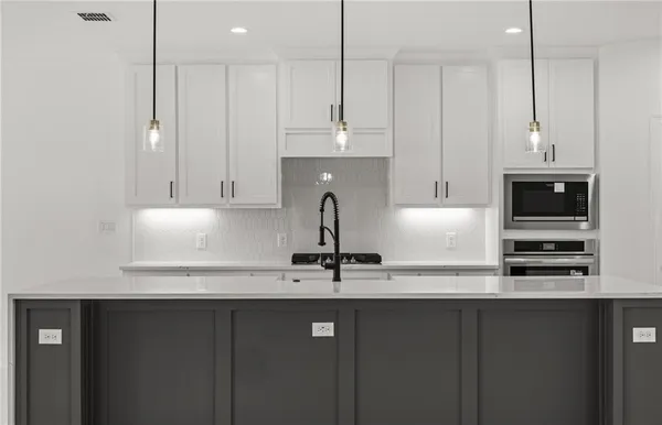 a kitchen with stainless steel appliances granite countertop a sink a stove and a refrigerator