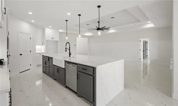 a large white kitchen with a large island oven a sink and appliances