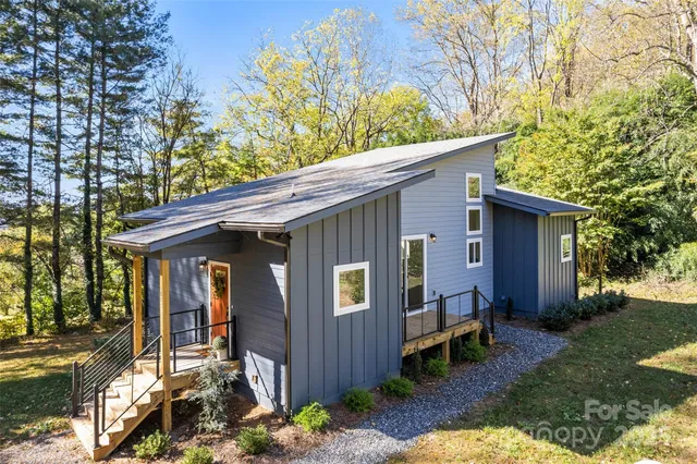 a view of a house with a yard chairs and table in a yard
