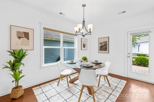 a dining room with furniture potted plants and wooden floor