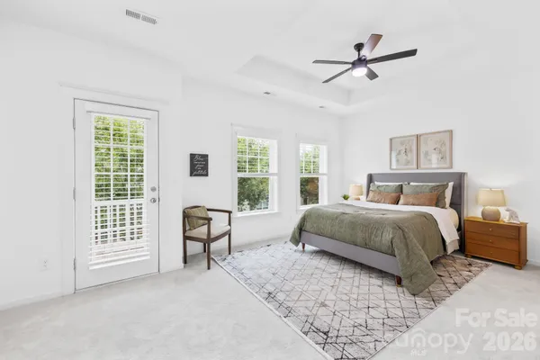 a bedroom with a bed a chair and a large window