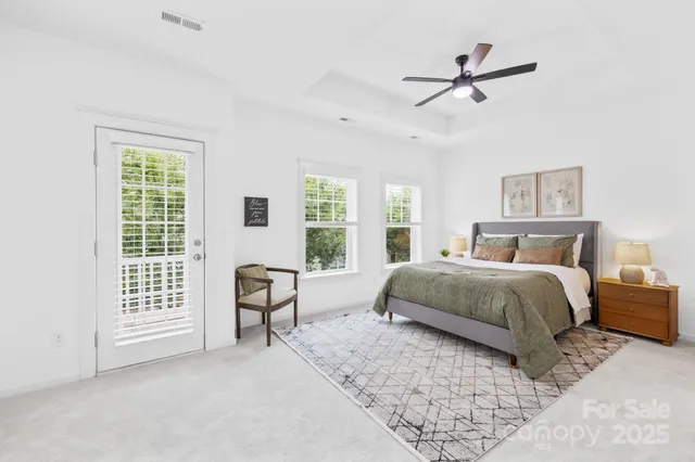 a bedroom with a bed a chair and a large window