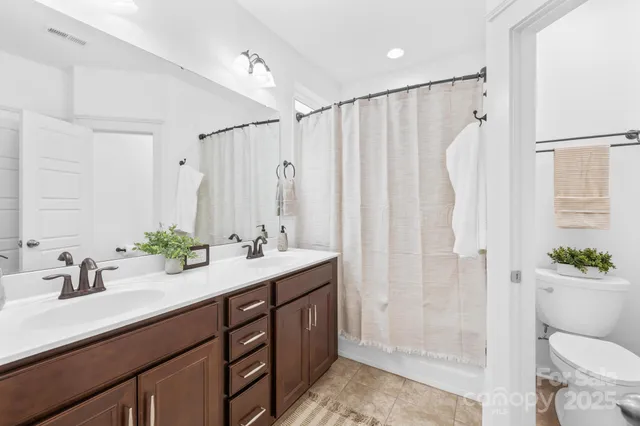 a bathroom with a double vanity sink toilet and shower